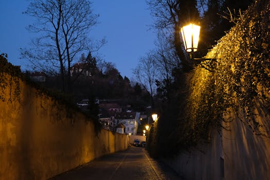 Explore the tranquil night ambiance of a historic street in Prague, illuminated by warm streetlights.