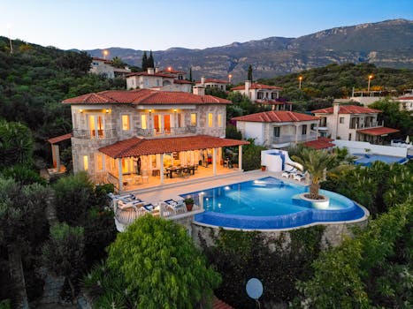 Stunning villa with infinity pool and mountain views during twilight.