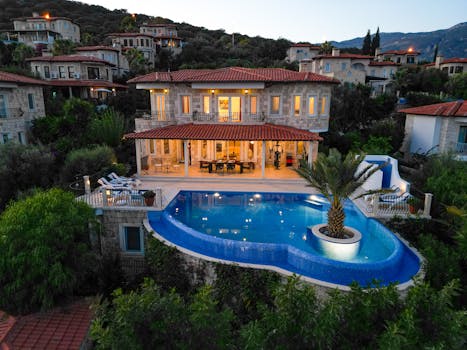 A stunning villa with an infinity pool overlooking beautiful scenery, captured at twilight.