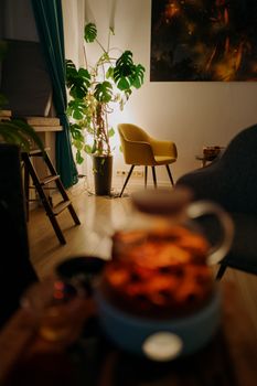 Warm and inviting living room with a yellow armchair, indoor plants, and soft lighting.