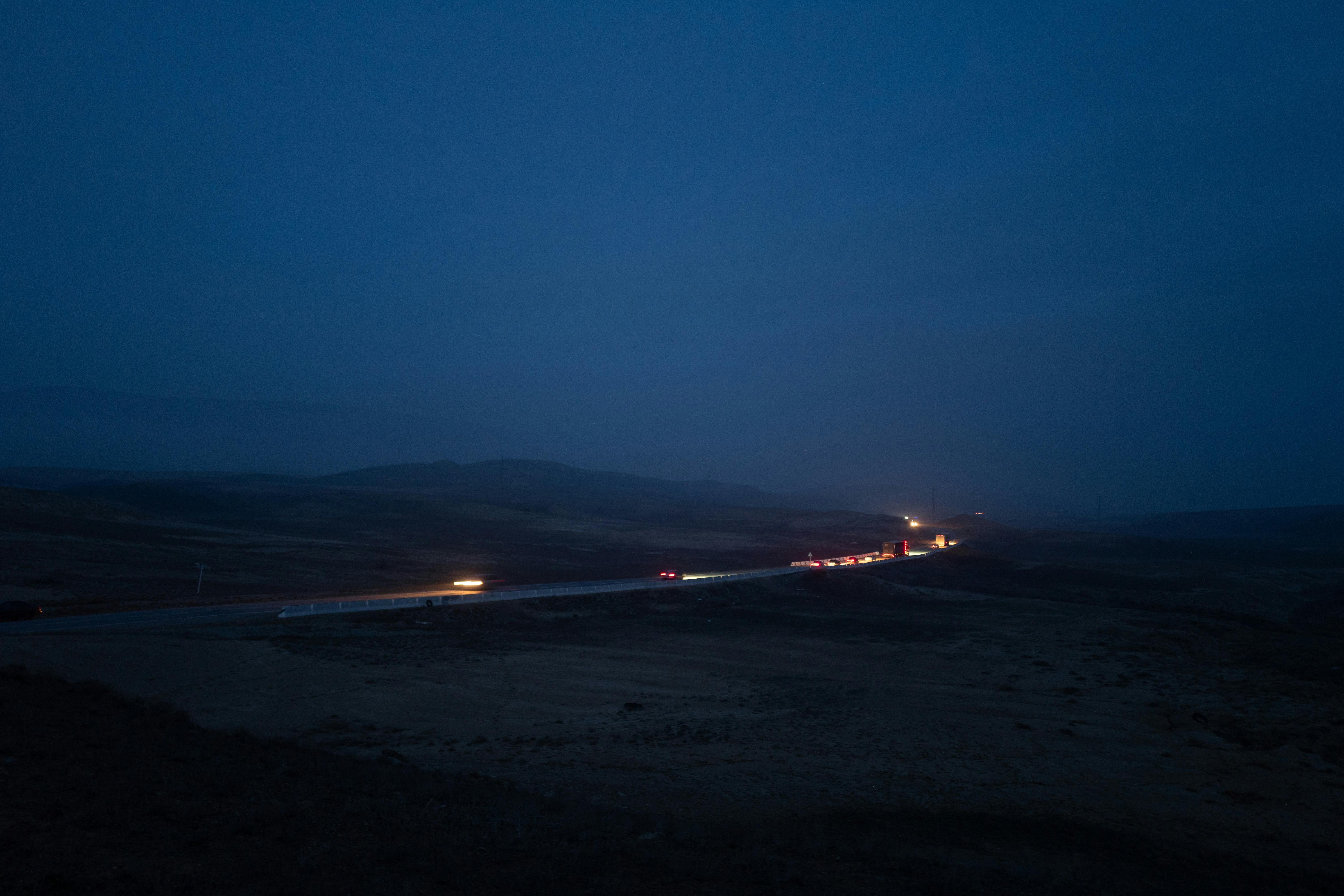 Free Long exposure of cars on a highway at night with minimal lighting, creating a serene nighttime scene. Stock Photo