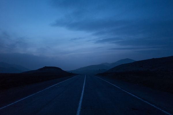 Mountain road under a blue twilight sky — photo by Daniil Ustinov on Pexels