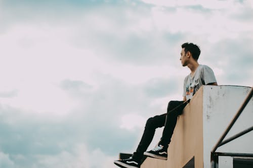 Man in Gray Shirt a Sitting on the Edge 