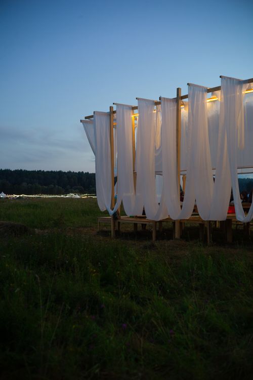 Free Evening ambiance at outdoor event with illuminated draped canopies in open field. Stock Photo