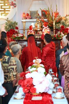 Vibrant traditional Asian wedding with red attire and decorations.