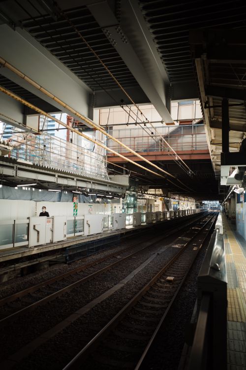 Free An empty train station platform with exposed beams and tracks, capturing a modern and urban atmosphere. Stock Photo