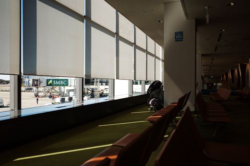 Free Empty airport terminal seating area with sunlight streaming in, showcasing a peaceful atmosphere. Stock Photo
