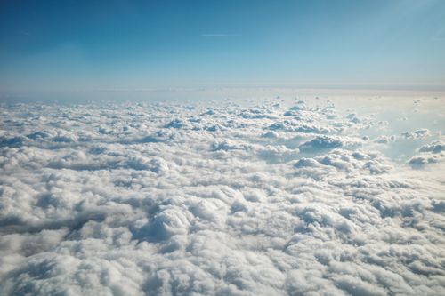 Free Expansive aerial view of fluffy clouds under a clear blue sky, creating a serene and heavenly atmosphere. Stock Photo