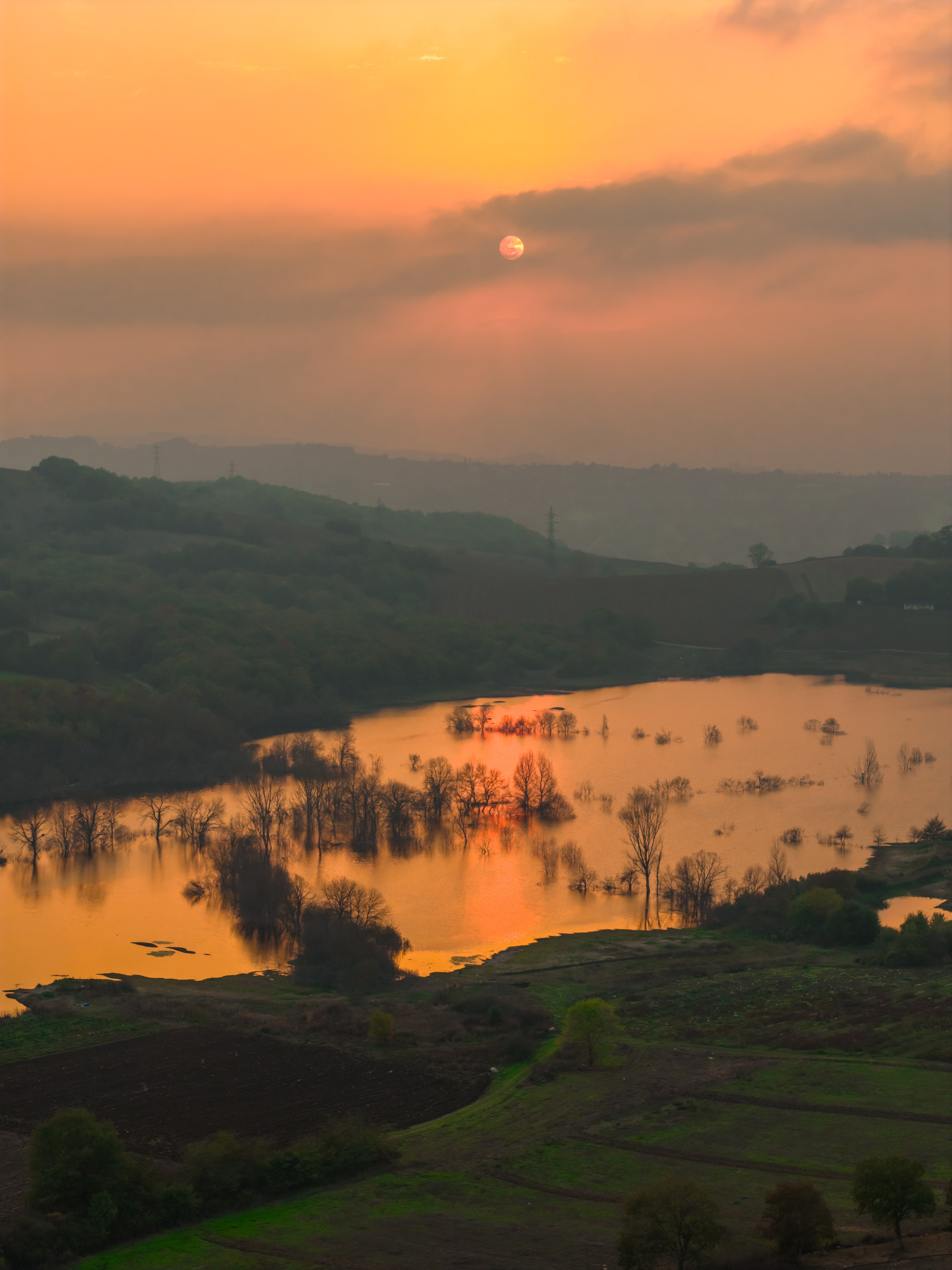 Beautiful sunset over a serene lake surrounded by lush hills in Turkey.