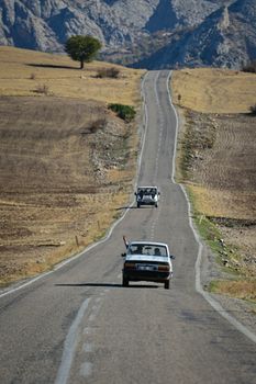 A car journey on a winding rural road surrounded by mountains in Kahta, Adıyaman.