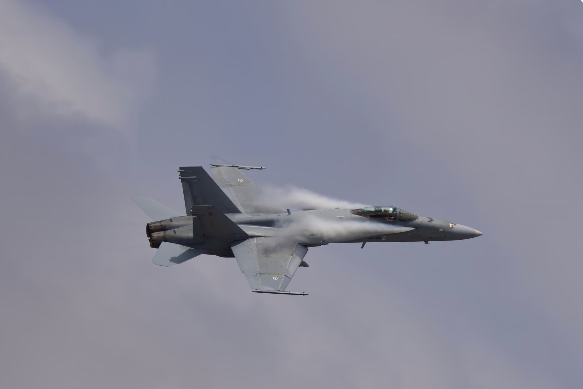 Un avion de chasse volant sous un ciel nuageux