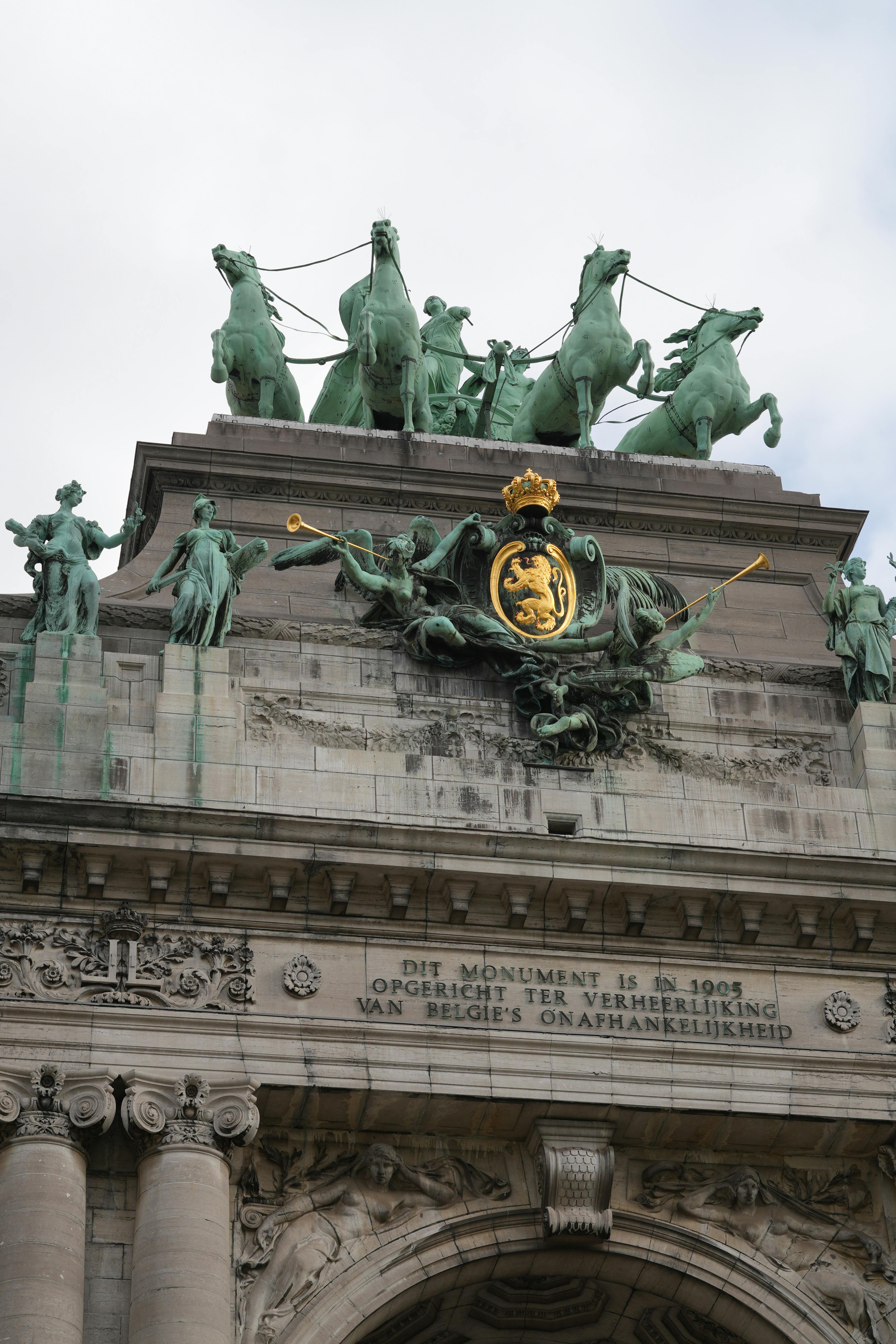 Detailed view of Brussels' iconic Cinquantenaire Arch featuring sculptures and inscriptions.