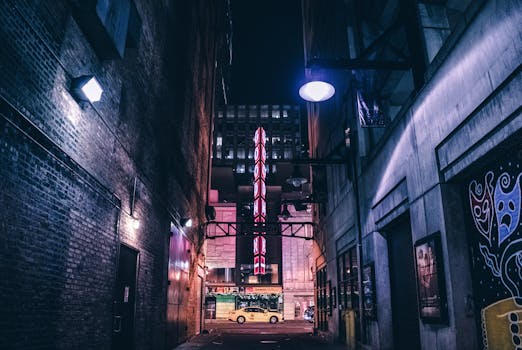 Discover the evocative mood of a Chicago alley at night with vibrant theater signage and soft lighting.