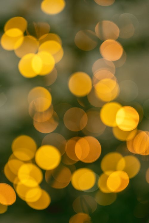 Free Beautiful abstract bokeh lights with a soft golden glow, perfect for festive or creative backgrounds. Stock Photo