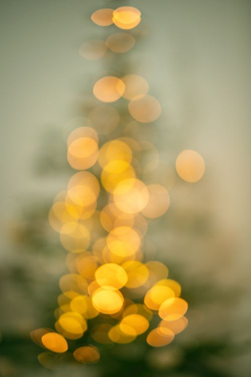 Free Abstract image of a Christmas tree with blurred golden bokeh lights creating a festive atmosphere. Stock Photo