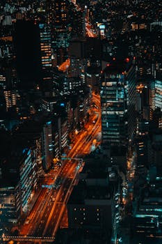 Vibrant aerial shot of Shibuya's illuminated skyline at night, showcasing bustling city life.