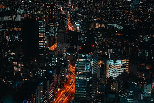 A vibrant aerial view of Shibuya's cityscape with glowing skyscrapers and bustling streets at night.