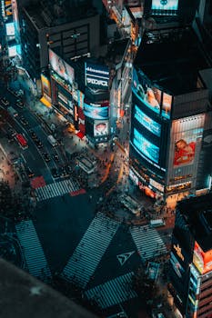 Dynamic night view of bustling Shibuya Crossing in Tokyo, Japan. Vibrant city life captured from above.