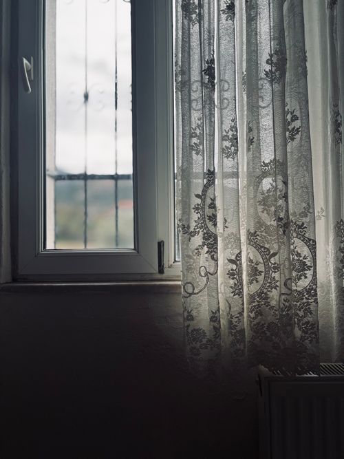 Free Calm indoor scene of a window with delicate lace curtains and natural light. Stock Photo