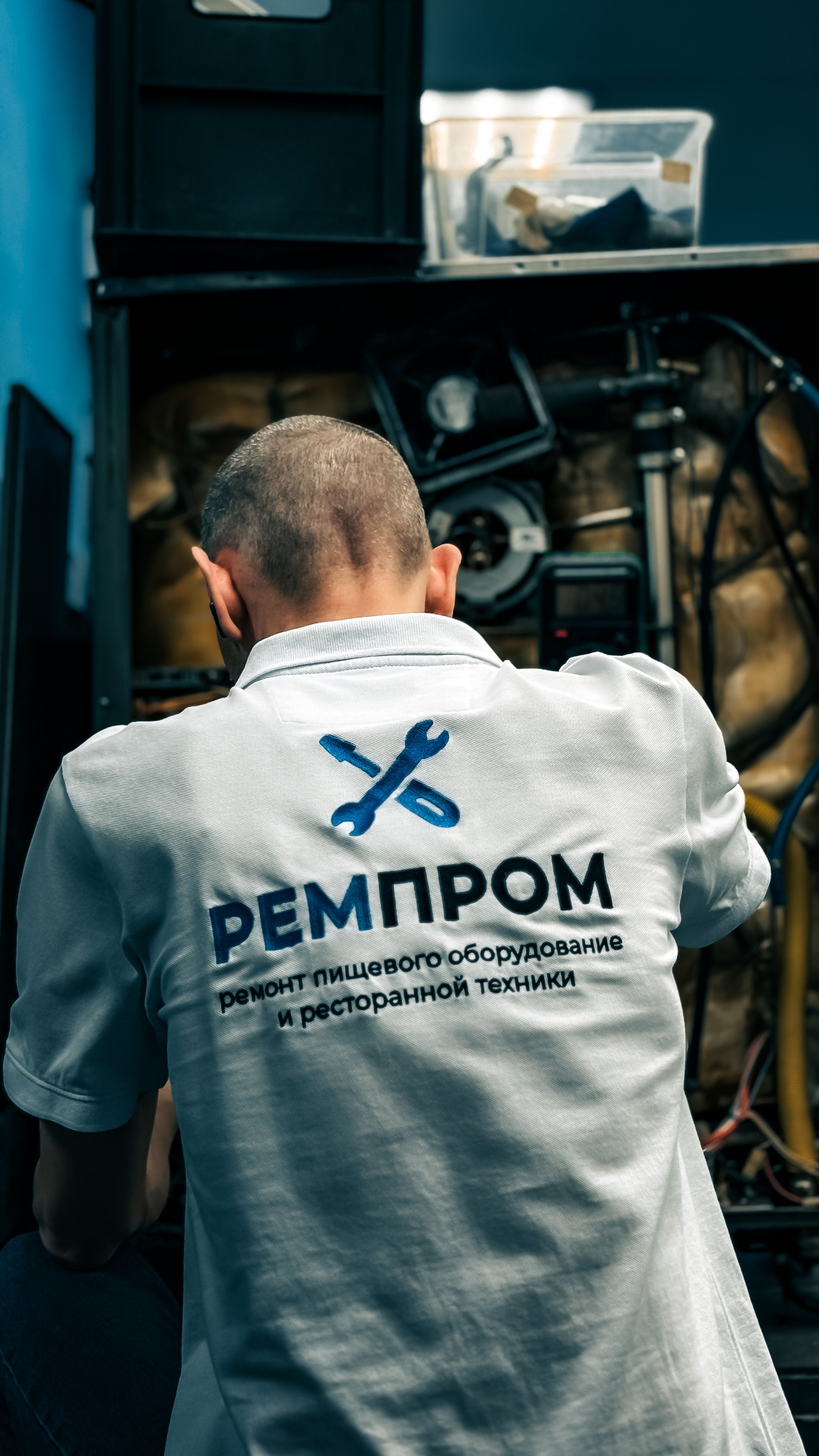 Back view of a technician fixing equipment, highlighting repair skills.