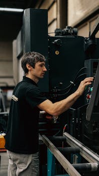A focused worker operating heavy machinery in an industrial setting.
