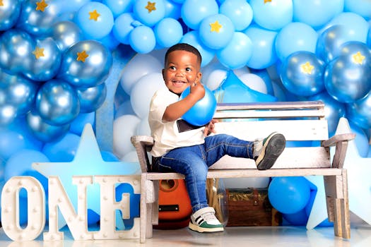 A joyful child celebrating their first birthday with blue balloon decorations.