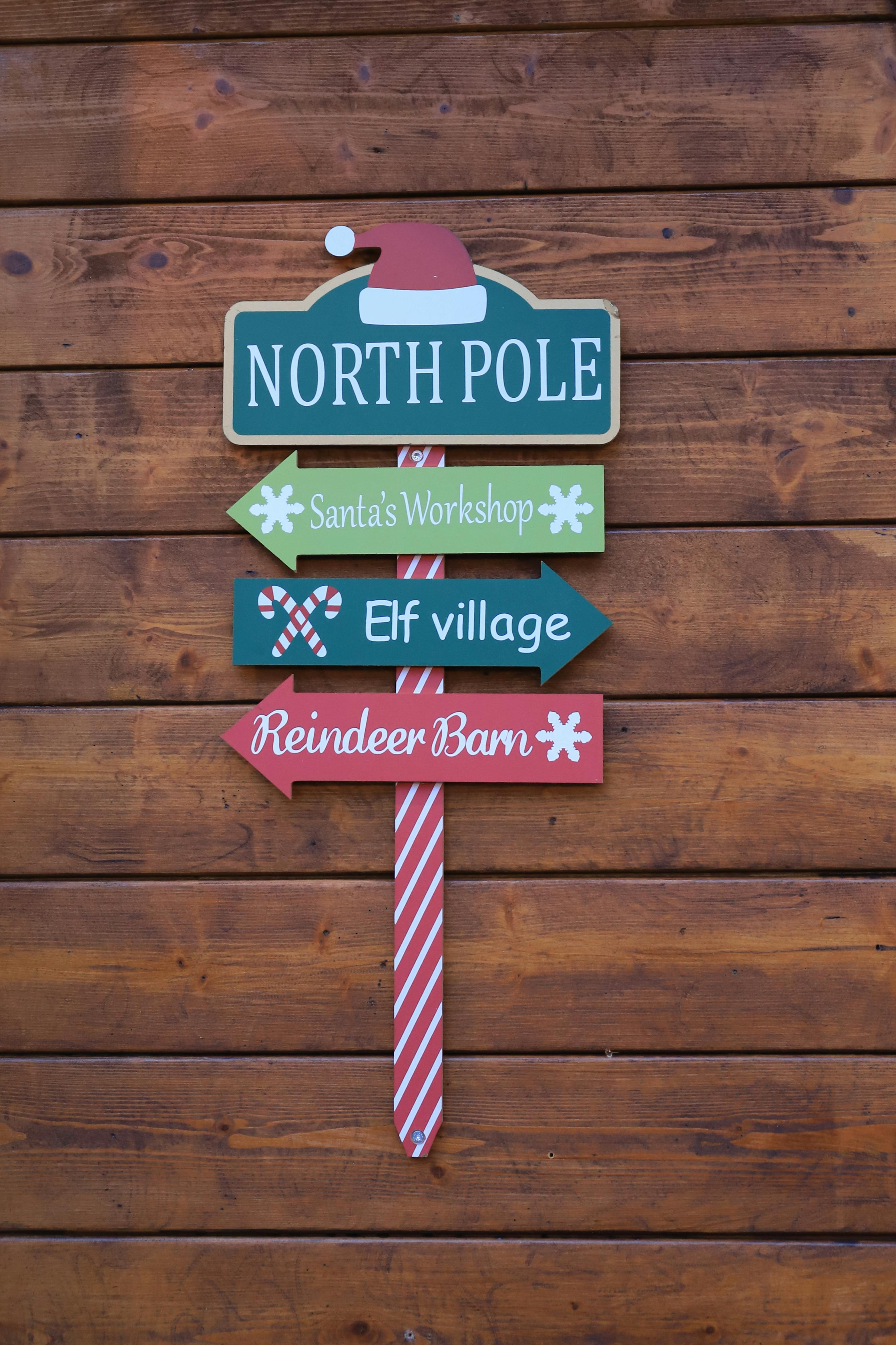 Colorful North Pole signpost at a Kassel Christmas market, evoking festive joy and holiday spirit.