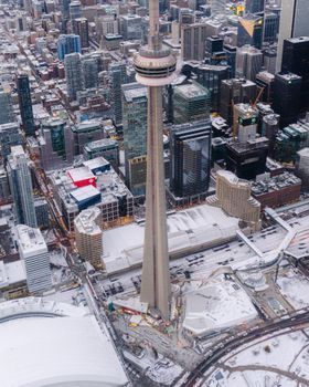 A stunning aerial view of the Toronto skyline featuring the iconic CN Tower amidst a snow-dusted cityscape.