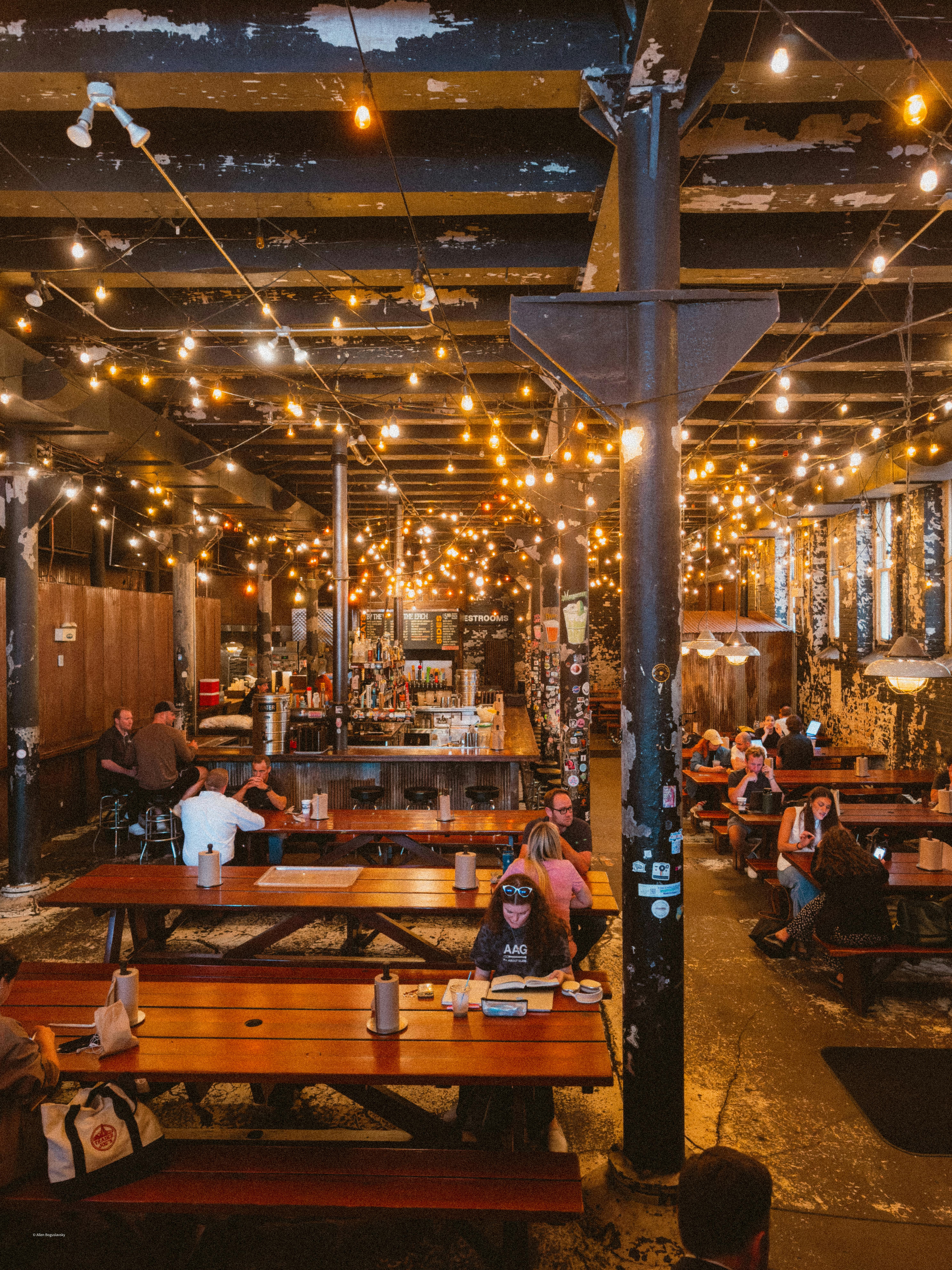 Ücretsiz Işık şeritleri ve yemek yiyen müşterilerle sıcak, endüstriyel restoran iç mekanı. Stok Fotoğraflar