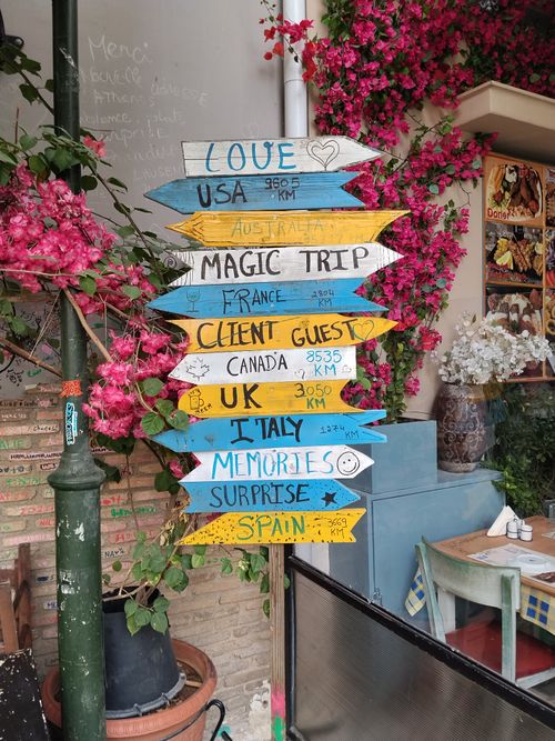 Free Colorful signpost with international destinations in vibrant cafe, Athens. Stock Photo