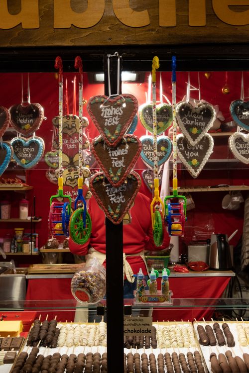 Free Christmas market stall showcasing heart-shaped gingerbread cookies at night in Germany, creating a festive atmosphere. Stock Photo