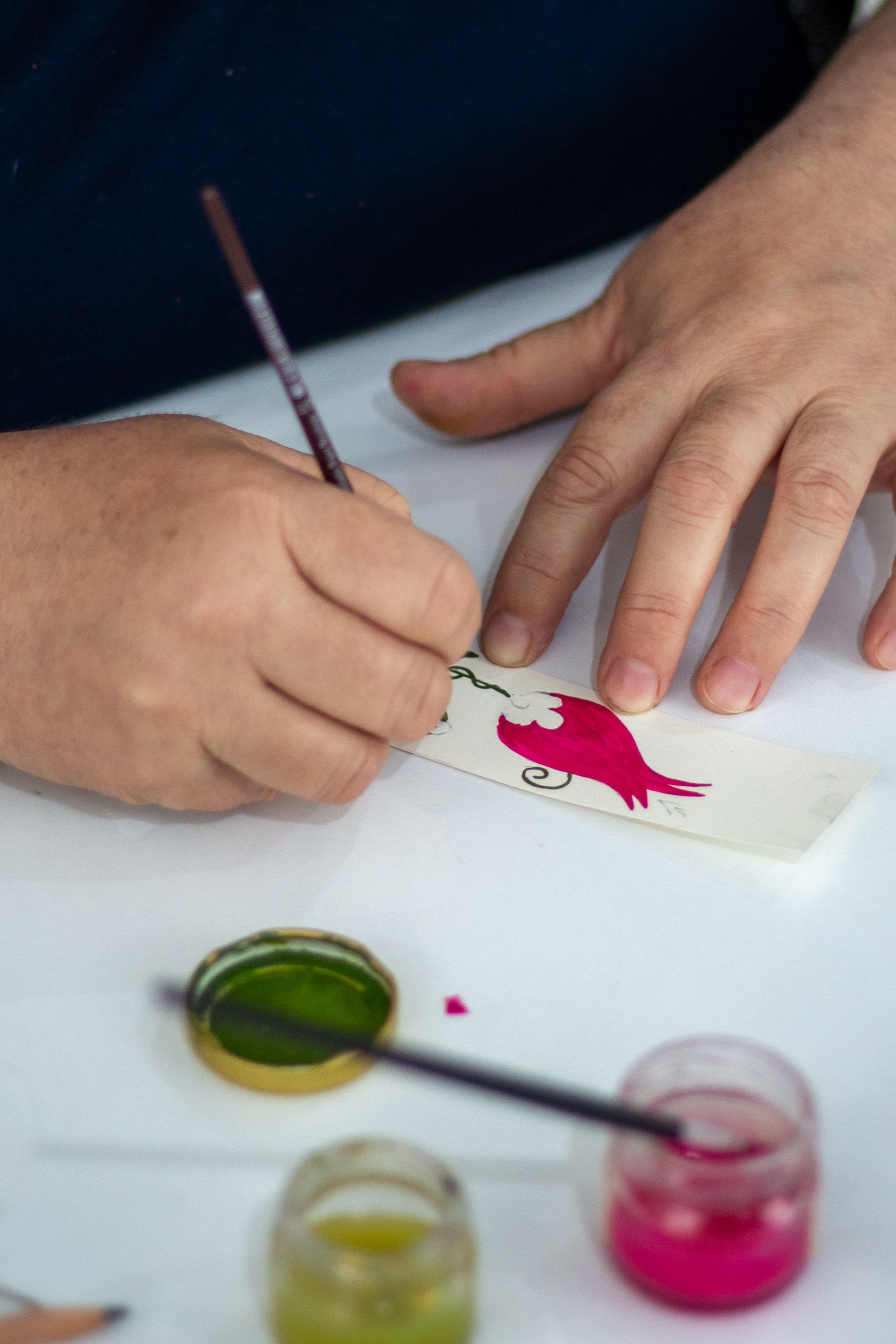 Gratuit Gros plan sur une main peignant un motif vibrant au pinceau et à l'encre. Photos