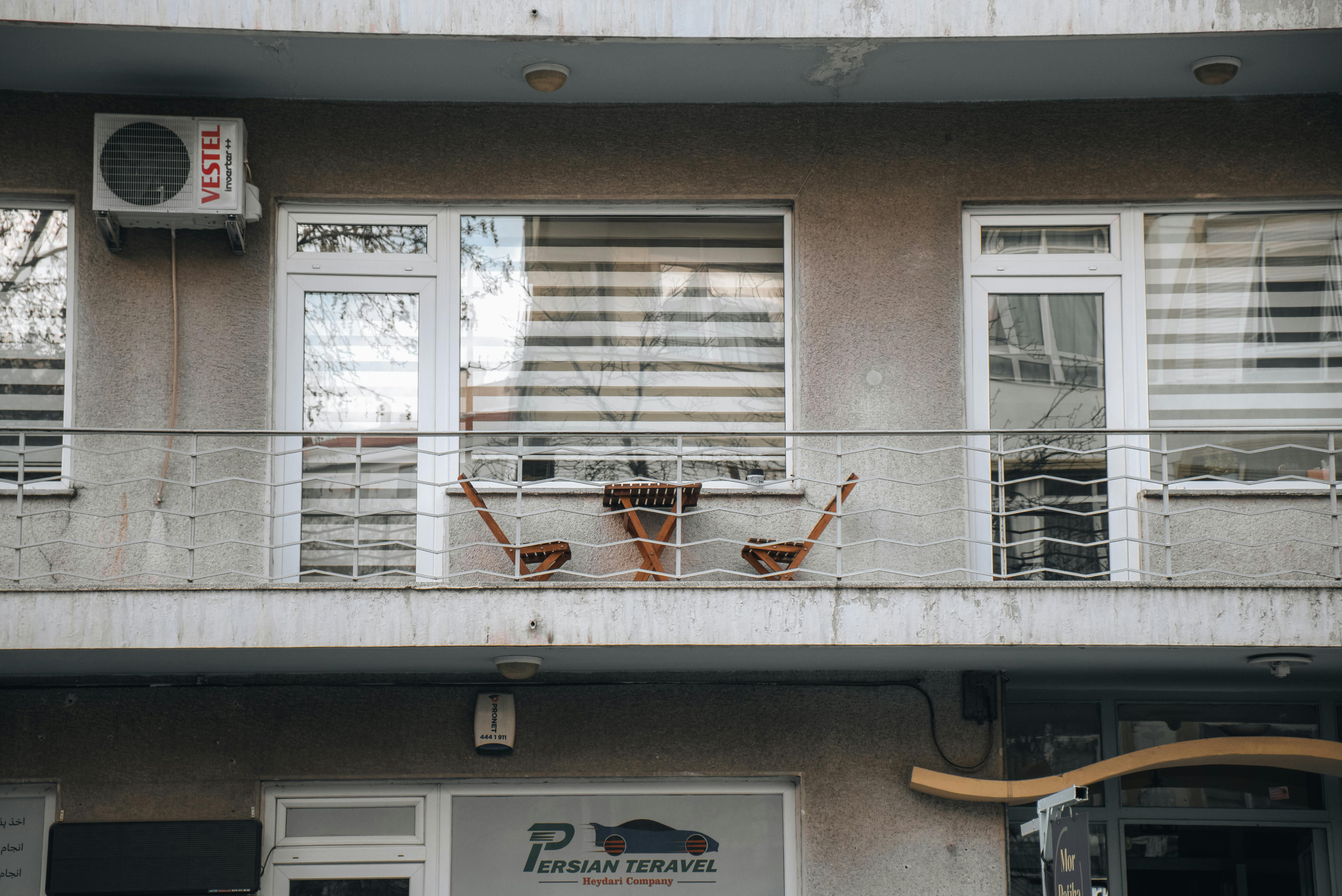 Ücretsiz Şehirde dinlenmek için mükemmel, iki sandalye ve dekora sahip, huzurlu bir şehir balkonu. Stok Fotoğraflar