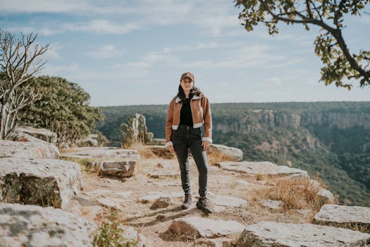 A woman enjoying a scenic hike on a rocky mountain trail surrounded by nature.