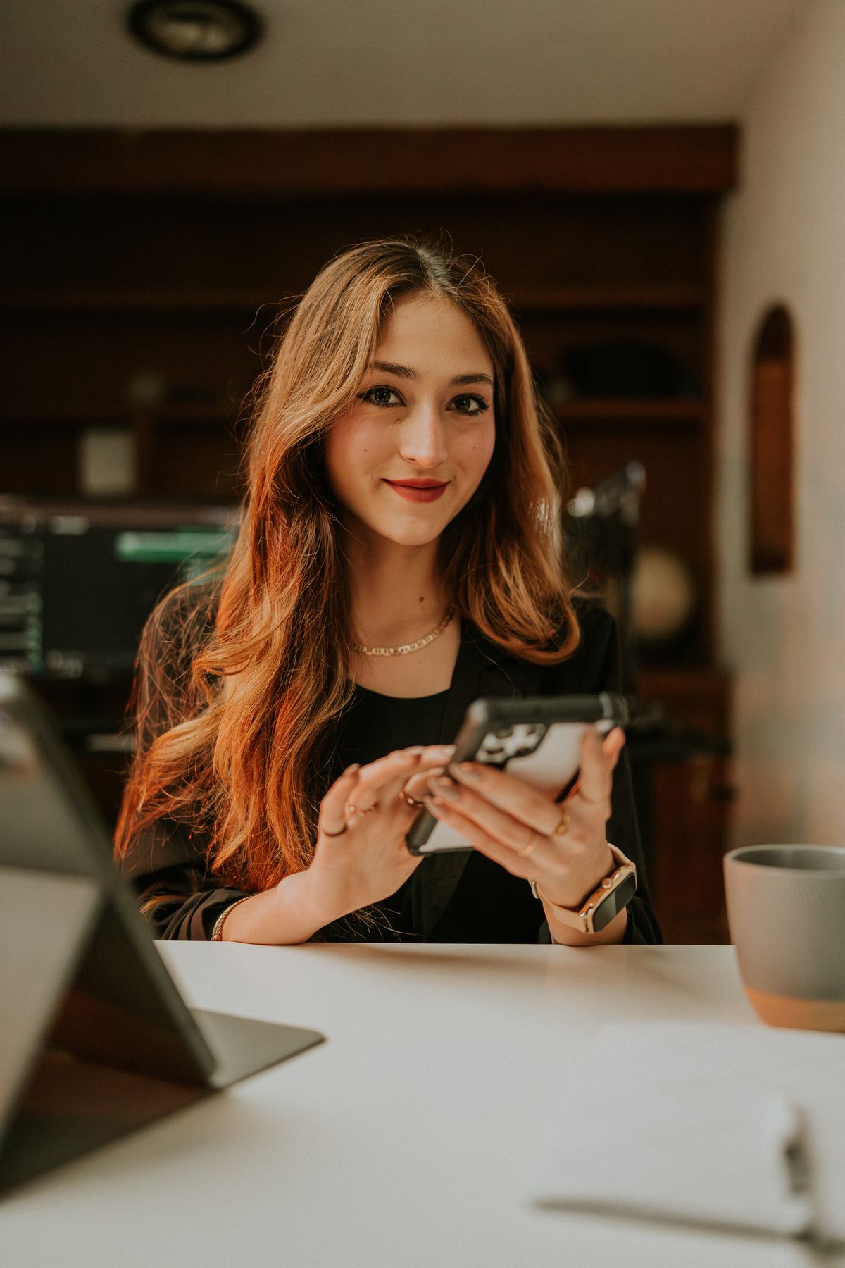 Mulher profissional sorrindo usando smartphone - Amar Preciado on Pexels