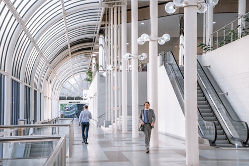 Men Walking in Hallway of Modern Building