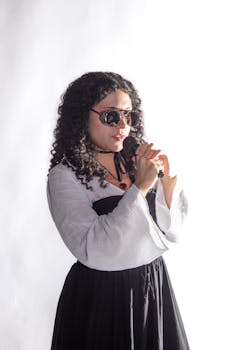 Portrait of a woman singing with a microphone in a studio setting, exuding confidence and style.
