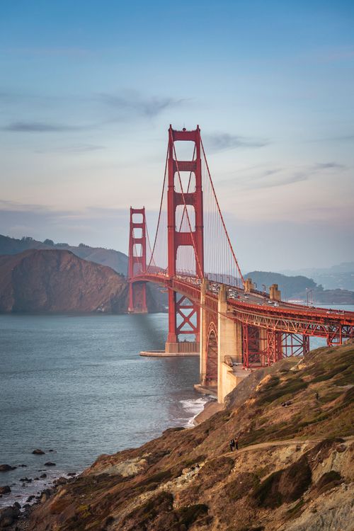 Free Scenic view of the iconic Golden Gate Bridge during sunset, showcasing its stunning architecture and natural surroundings. Stock Photo