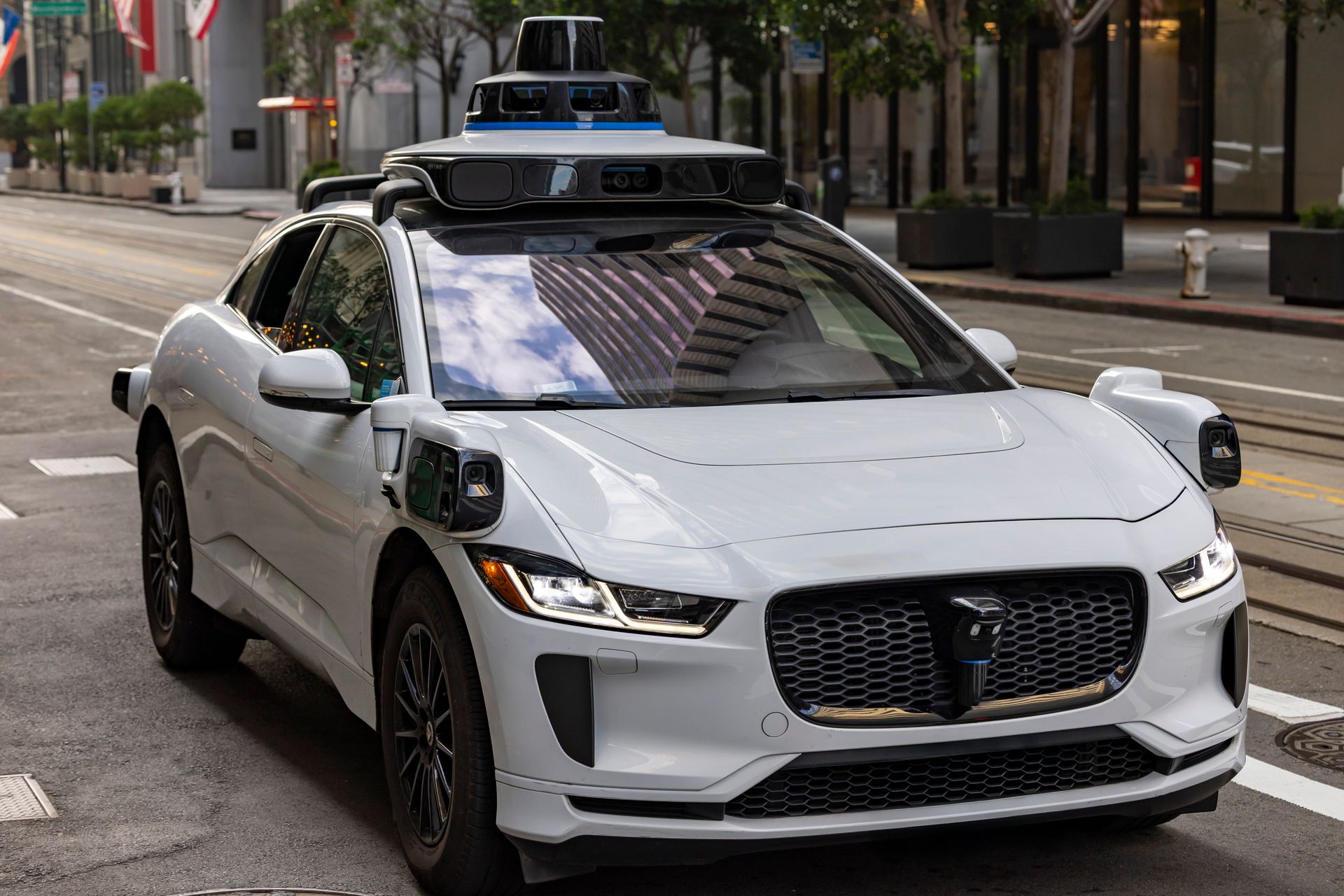 An autonomous vehicle moving along a city street during the day.