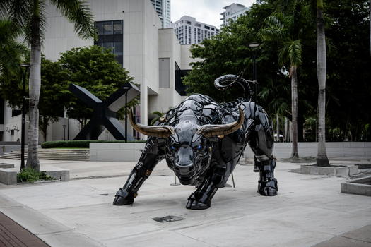 Een opvallend stierenbeeld in Miami, omringd door moderne architectuur en weelderig groen.