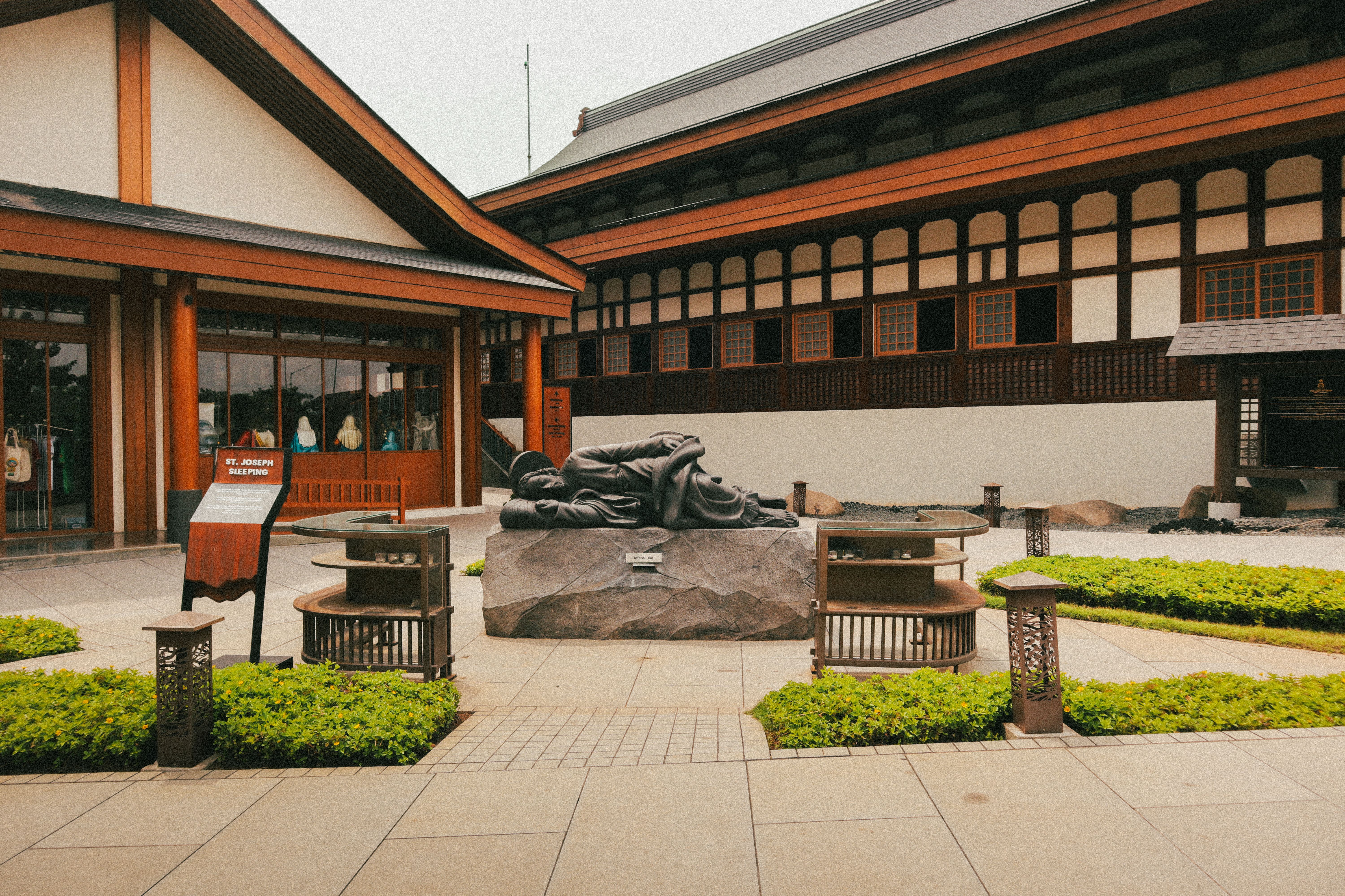 Serene courtyard with a Sleeping Buddha statue and Japanese architecture.