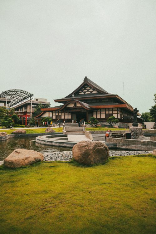 Free Serene Japanese temple architecture surrounded by tranquil garden and pond, ideal for travel inspiration. Stock Photo
