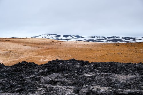 Free Breathtaking view of Þingeyjarsveit volcanic terrain with snow and lava contrast. Stock Photo