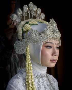Close-up of a bride in traditional Sundanese wedding attire with intricate siger headdress.