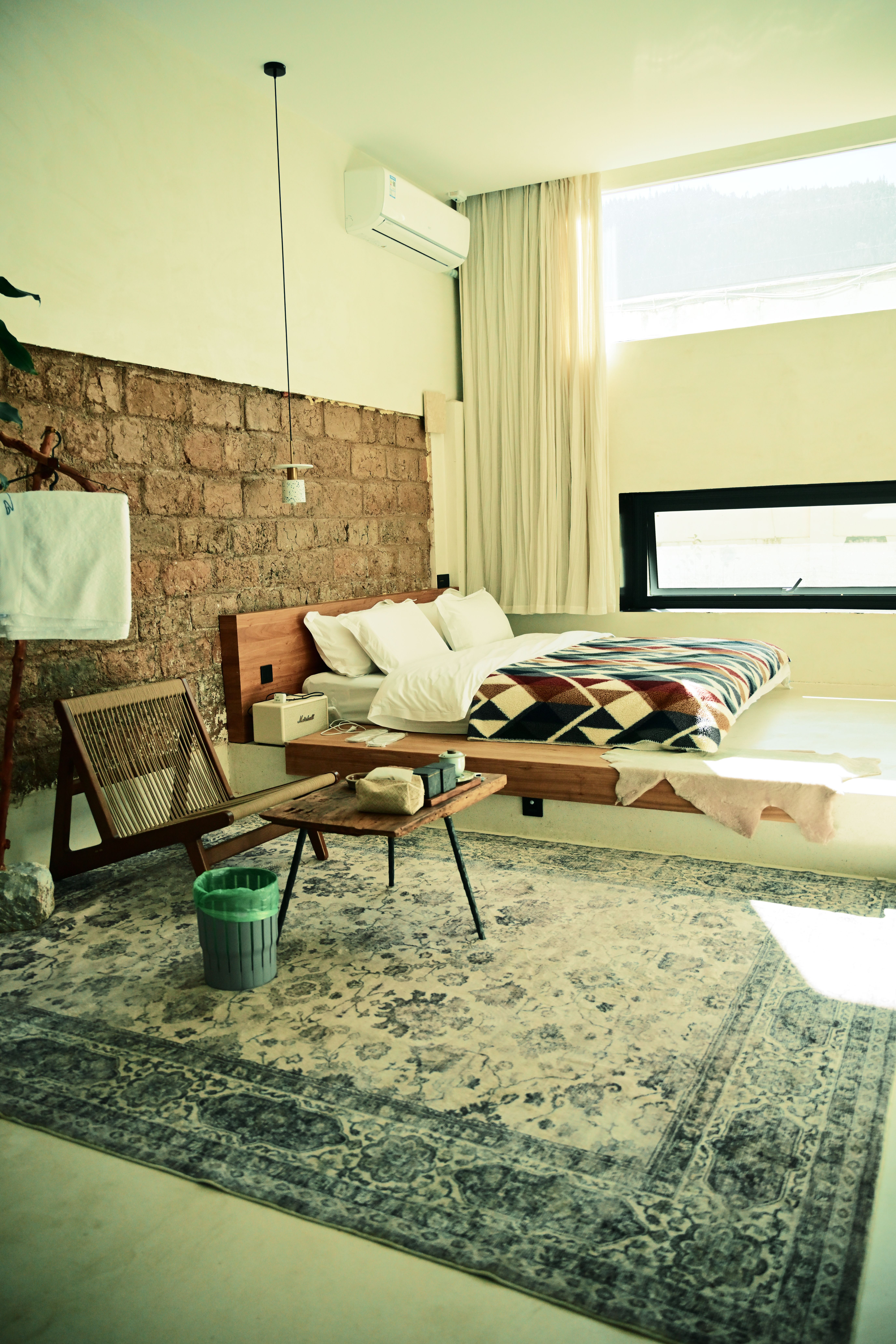 Spacious modern bedroom featuring minimalist decor and large window with natural light.