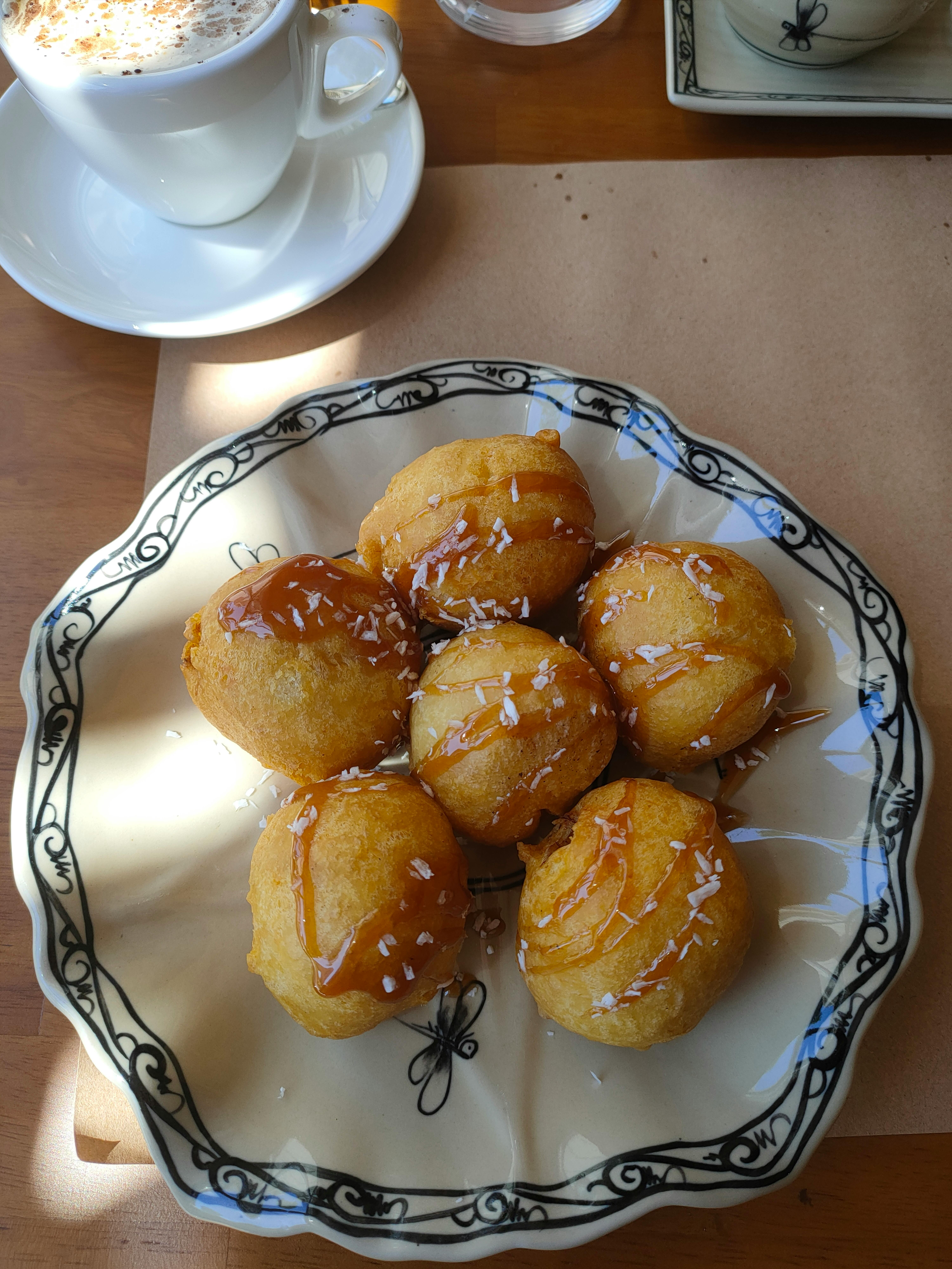 Tasty caramel-glazed donuts served with coffee, perfect for a sweet break.
