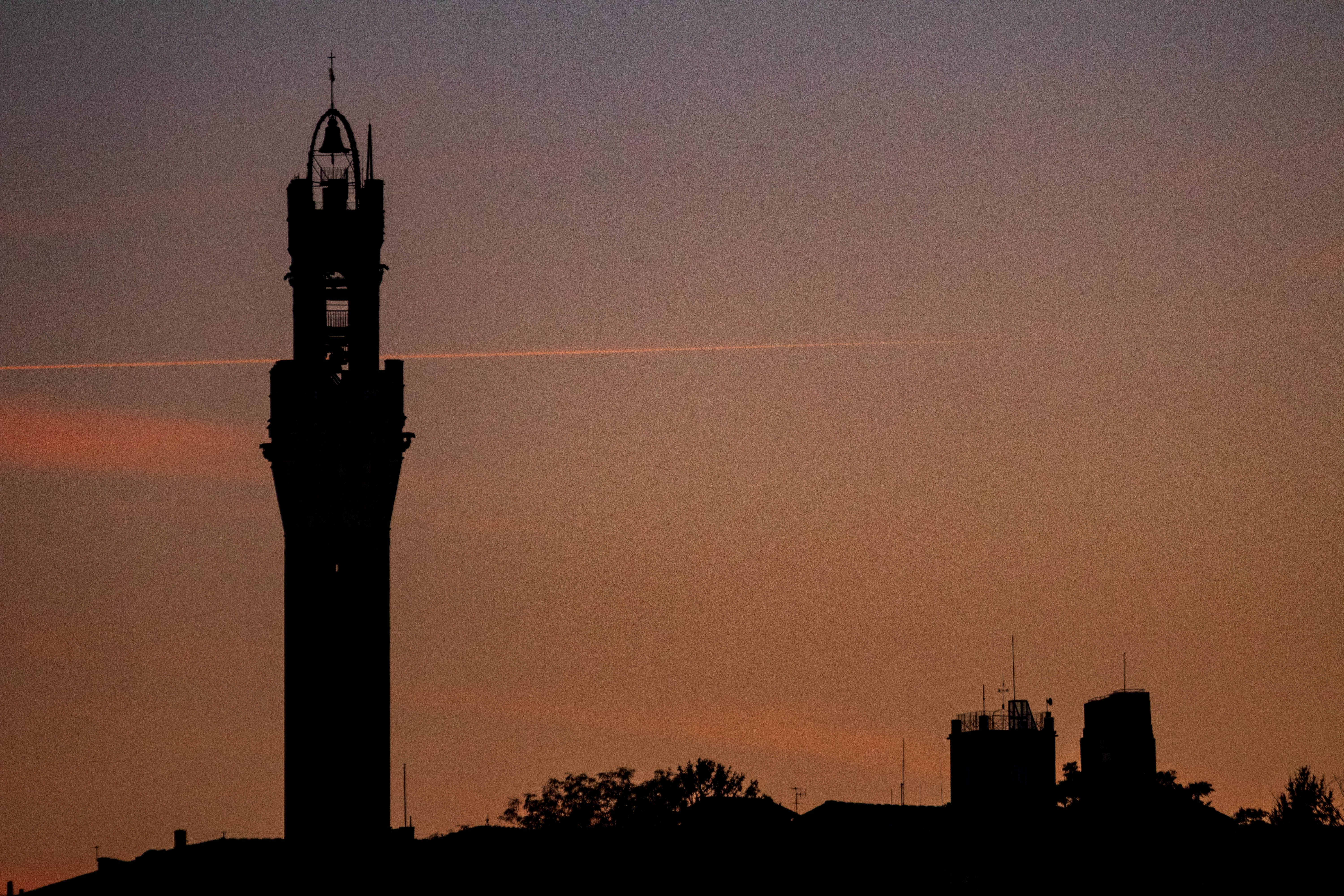 Silhouette of Tower Against Vibrant Sunset Sky · Free Stock Photo