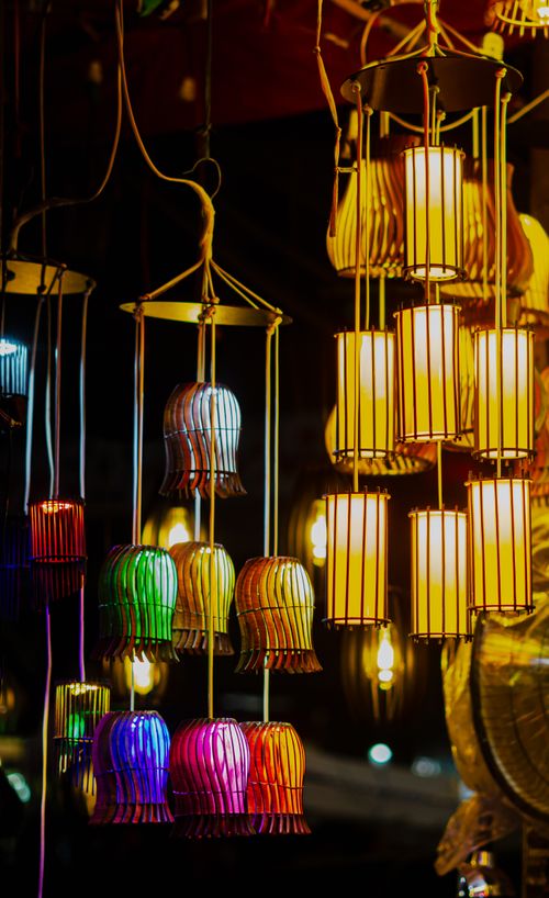 Free Colorful hanging lanterns glowing brightly in a night market, showcasing vivid light and shadow play. Stock Photo