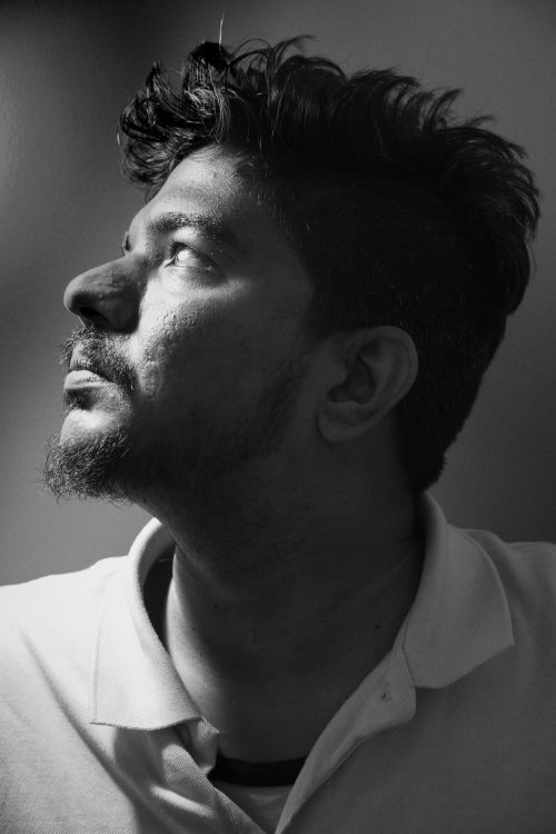 Free A thoughtful black and white portrait of a man gazing upward in an introspective pose. Stock Photo
