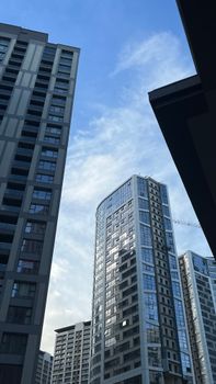 Contemporary city skyscrapers with a clear blue sky backdrop.
